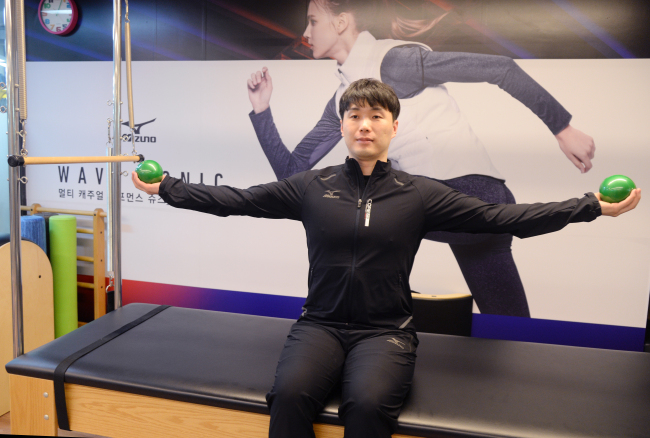 Lee Su-yeol performs a simple exercise beginners can try at home using mini balls to improve muscle tone in one’s arms. (Park Hyun-koo/The Korea Herald)