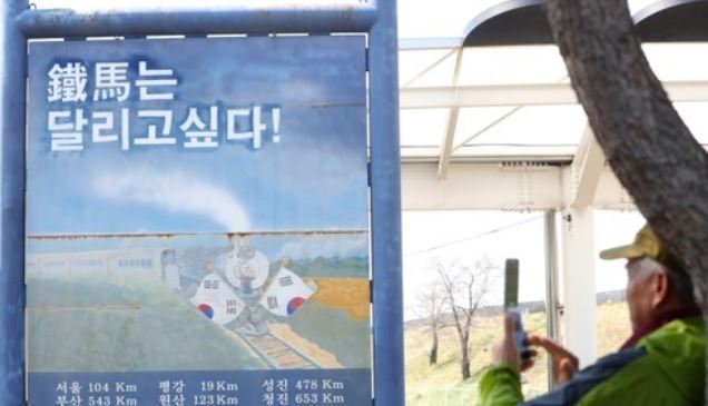 In this photo taken April 27, a man takes a photo of a bulletin that reads 