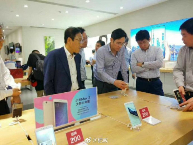 Samsung Electronics Vice Chairman Lee Jae-yong (second left) looks at a Xiaomi smartphone at an electronics shop in Shenzhen on Thursday. (Yonhap/Weibo)