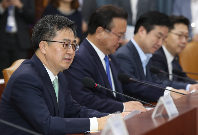 Finance Minister Kim Dong-yeon (left) outlines the government's FX intervention disclosure policy at an economy-related ministers meeting in Seoul on May 17, 2018. (Yonhap)