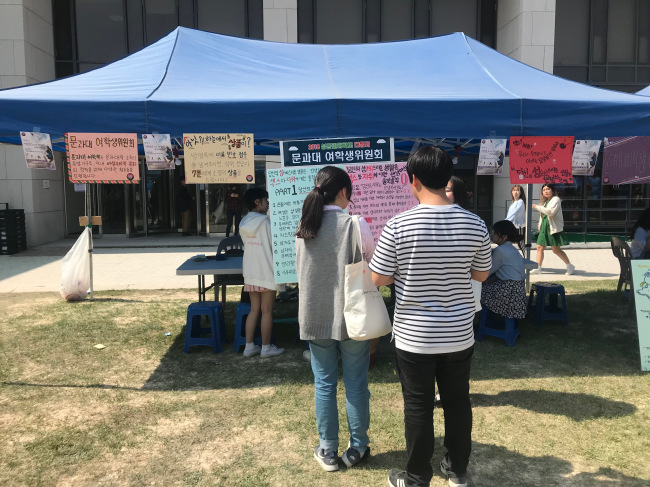 Two students answer true or false questions from the Student Council for Women of the Liberal Arts College‘s booth. (Photo by Ahn Sang-yool/The Korea Herald)