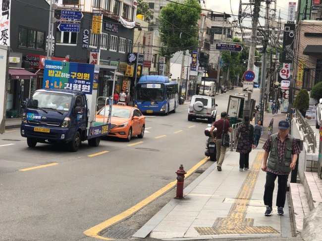 An election canvassing truck of a city council member nominee from the ruling Democratic Party of Korea drives through a street in Itaewon, central Seoul on Monday. (Jo He-rim/The Korea Herald)