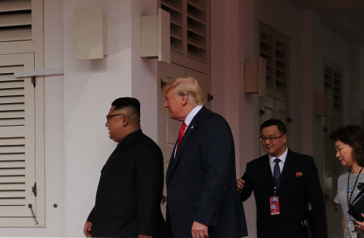 US President Donald Trump walks with North Korean leader Kim Jong-un at the Capella Hotel on Sentosa island in Singapore June 12, 2018. (Reuters-Yonhap)