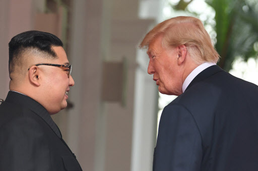 North Korea's leader Kim Jong-un (L) and US President Donald Trump meet at the start of their historic US-North Korea summit, at the Capella Hotel on Sentosa island in Singapore on Tuesday. Donald Trump and Kim Jong-un have become on June 12 the first sitting US and North Korean leaders to meet, shake hands and negotiate to end a decades-old nuclear stand-off. (AFP-Yonhap)
