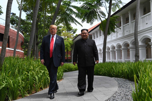 North Korea's leader Kim Jong-un (R) walks with US President Donald Trump (L) during a break in talks at their historic US-North Korea summit, at the Capella Hotel on Sentosa island in Singapore on June 12, 2018. Donald Trump and Kim Jong-un became on June 12 the first sitting US and North Korean leaders to meet, shake hands and negotiate to end a decades-old nuclear stand-off. / AFP PHOTO