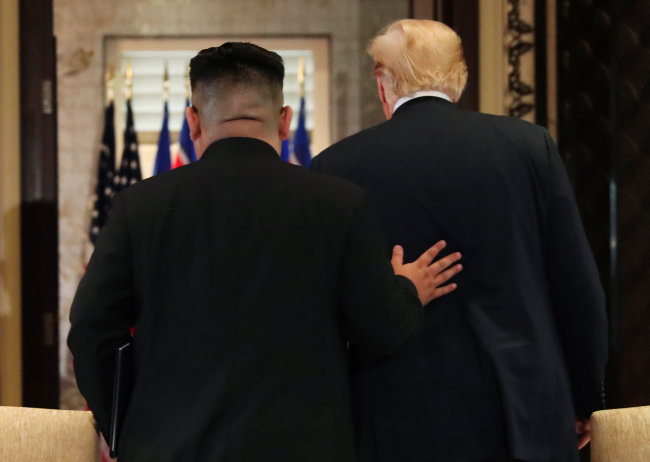 Trump and Kim leave after signing documents that acknowledge the progress of the talks and pledge to keep momentum going. (Reuters-Yonhap)