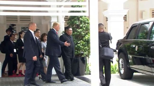 President Donald Trump shows North Korean leader Kim Jong-un the Cadillac One presidential limo during their walk near Capella Hotel on the resort island of Sentosa, Singapore Tuesday. (Yonhap)