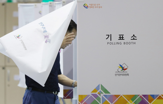 A citizen enters a polling booth in Seoul's Seodaemun-gu on Wednesday, the day of the nation's June 13 local and parliamentary by-elections. (Yonhap)