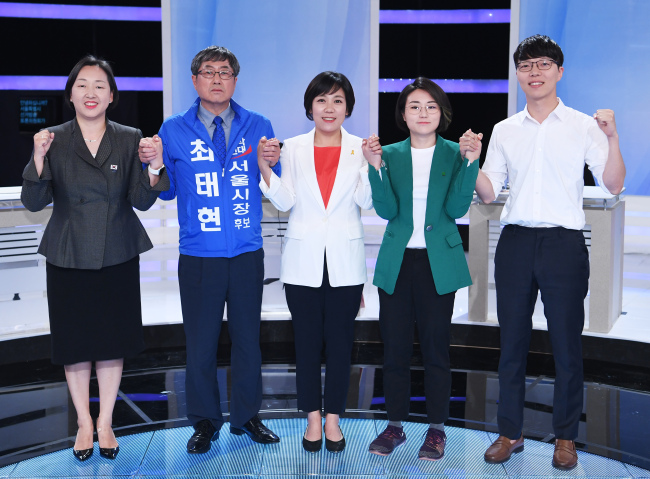 Seoul mayoral candidates from small parties hold hands in a televised debate hosted by the National Election Commission on June 4. From left: In Ji-yeon of the Korea Patriots Party, Choi Tae-hyun of the New Politics Party, Kim Jin-sook of the Minjung Party, Shin Ji-ye of the Green Party Korea and Woo In-cheol of Our Future Party. (Yonhap)