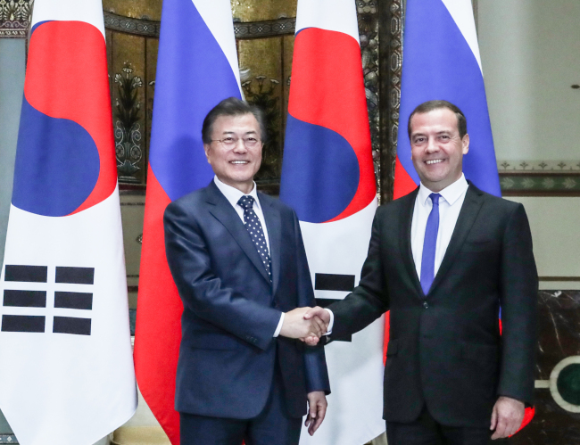 President Moon and Russian Prime Minister Medvedev pose before holding talks in Moscow on Thursday. (Joint Press Corps)