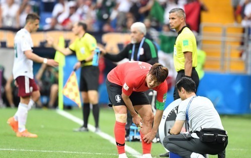 South Korea's Ki Sung-yueng receives medical treatment during the 2018 FIFA World Cup Group F match between South Korea and Mexico at Rostov Arena in Rostov-on-Don on June 23, 2018. (Yonhap)