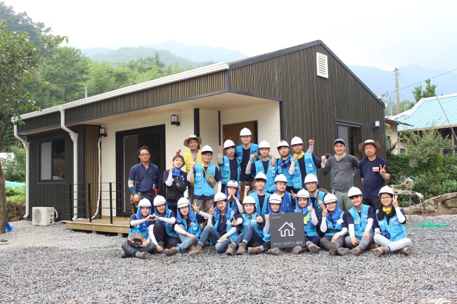 The 11th group of members of Beyond pose in front of the 25th steel house built in Gwangyang city, South Jeolla Province, during a ceremony in July 2017. (Posco)