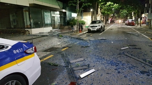 A telephone pole transformer explosion damages a patrol car in front of the Nampo Police Office in Busan on Wednesday. (Busan Metropolitan Police Agency)