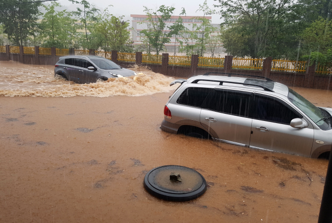 Cars are submerged in a street in Boseong-gun, South Jeolla Province on Sunday morning. (Yonhap)