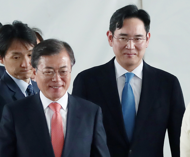 President Moon Jae-in (left) is accompanied by Samsung heir Lee Jae-yong at Samsung's smartphone production facility in Noida, India, on Monday. (Yonhap)