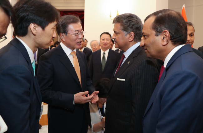 President Moon Jae-in (second from left) talks Mahindra Chairman Anand Mahindra during a roundtable session for business leaders from South Korea and India. Next to the chairman is Pawan Goenka, managing director of Mahindra Group and the chairman of SsangYong board. (Yonhap)