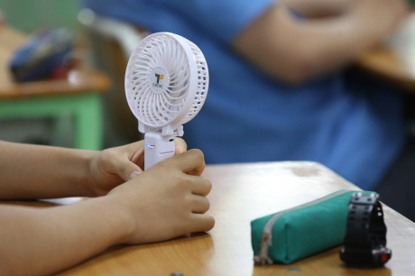 Photo caption: A student uses a portable fan at a classroom. (Yonhap)