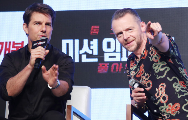 Tom Cruise (left) speaks while Simon Pegg points to reporters during a press conference for “Mission: Impossible – Fallout” in Seoul on Monday. (Yonhap)