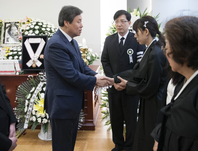 Do Jong-hwan (left) talks with the bereaved family of novelist Choi In-hun at a funeral parlor in Seoul on Tuesday. (Yonhap)