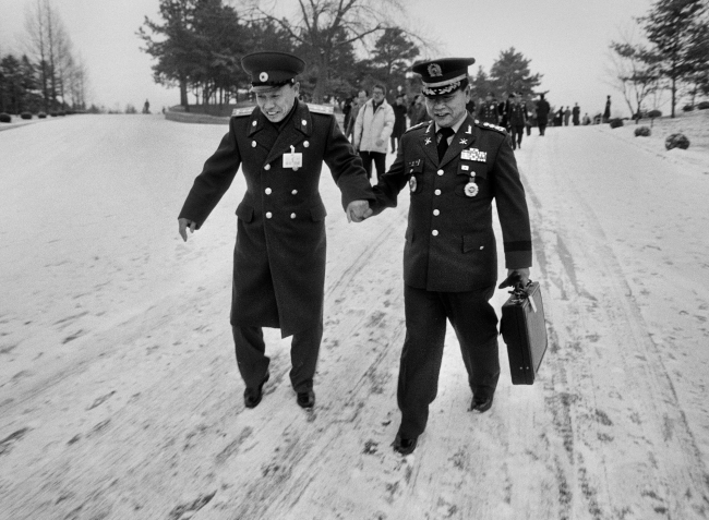 Kim Nyung-man’s 1992 photo shows a South Korean military officer and a North Korean officer holding hands at Panmunjom. (Courtesy of the artist)