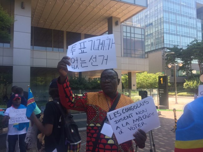 A Congolese protester holds a sign that says 