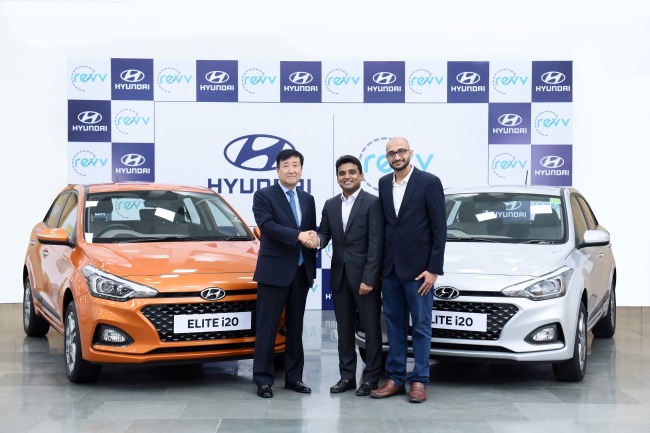 Koo Young-ki, head of Hyundai Motor India shakes hands with Karan Jain, co-founder of Revv at the carmaker's product quality center in India. Next to Jain is Anupam Agarwal, also a co-founder of Revv. (Hyundai Motor)