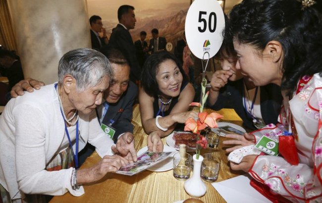 South Korean Lee Keum-seom, 92, left, watches a photo with her North Korean son Ri Sang Chol, 71, second from left during the Separated Family Reunion Meeting at the Diamond Mountain resort in North Korea, Monday, Aug. 20. (AP)