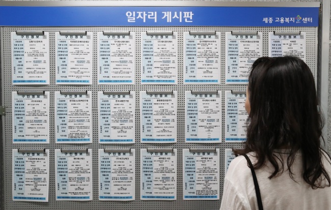 A young Korean woman reads about job openings at a labor office in Seoul. (Yonhap)