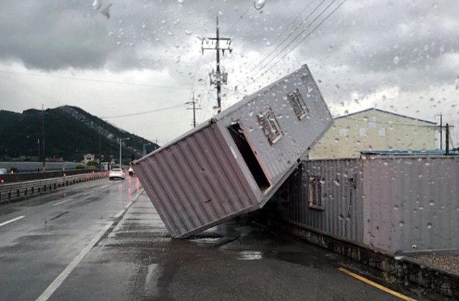 A cargo container rests precariously on another one in the southern port city of Yeosu on Friday. (Yonhap)