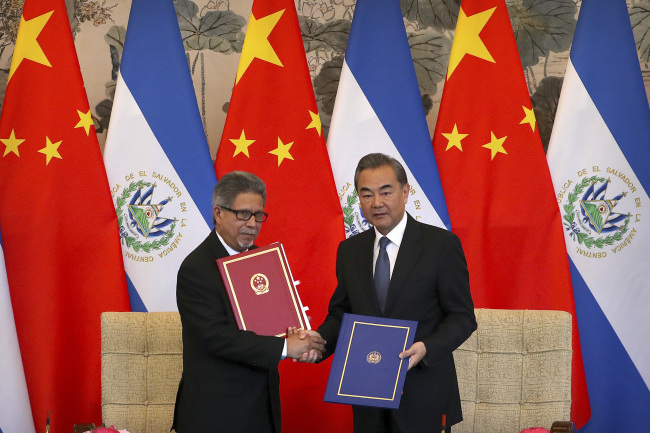 In this Aug. 21, 2018 photo, El Salvador’s Foreign Minister Carlos Castaneda, left, and China’s Foreign Minister Wang Yi shake hands at a signing ceremony to mark the establishment of diplomatic relations between the two countries at the Diaoyutai State Guesthouse in Beijing. Taiwan broke off diplomatic ties with El Salvador on Tuesday as the Central American country defected to rival Beijing in the latest blow to the self-ruled island China has been trying to isolate on the global stage. (AP-Yonhap)