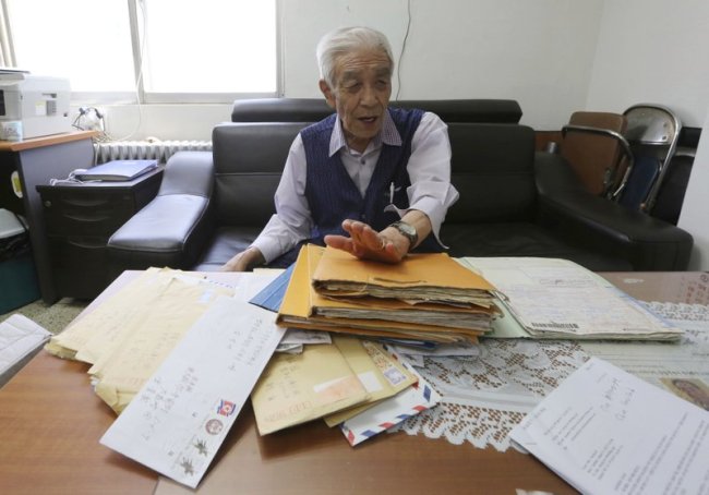 In this Aug. 22 photo, Kim Kyung-jae, 86, speaks in front of letters sent from his North Korean sister during an interview at his office in Seoul, South Korea. (AP)