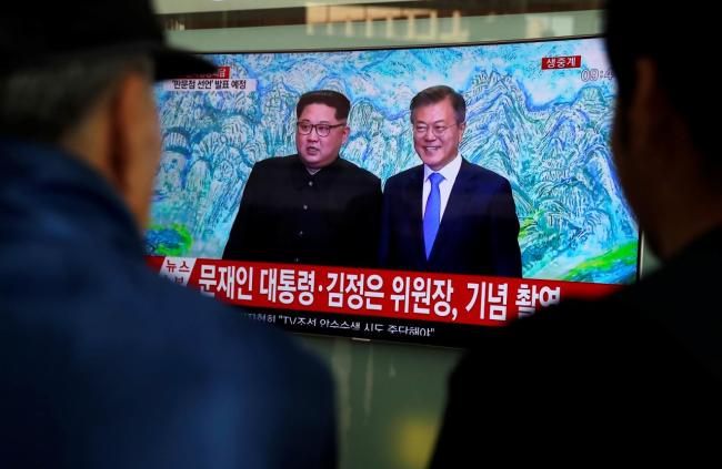 People watch a TV showing a live broadcast of the inter-Korean summit, at a railway station in Seoul, South Korea, April 27. (Reuters)