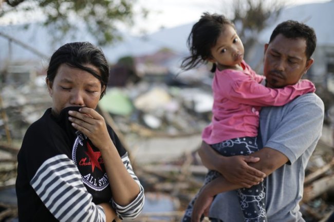 Musrifah, left, cries beside her husband Hakim and daughter Syafa Ramadi as they visit the area where their house used to stand.(AP)