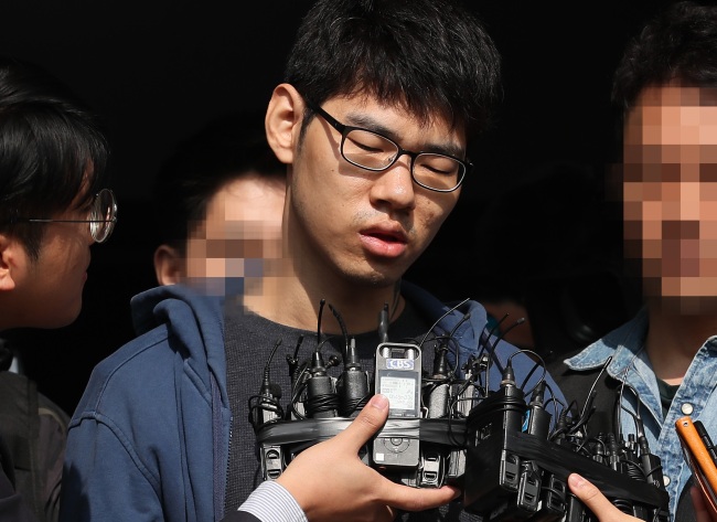 Kim Seong-su, a suspect in the murder of an internet cafe employee, answers questions from reporters as he steps out of the Yangcheon Police Station in Seoul on Monday. (Yonhap)