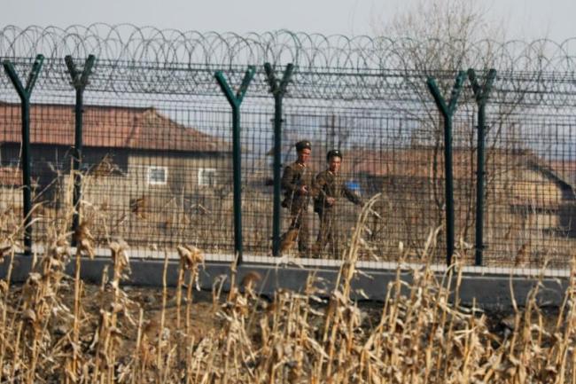 North Korean soldiers patrol behind a border fence near the North Korean town of Sinuiju, March 31, 2017. (Reuters)