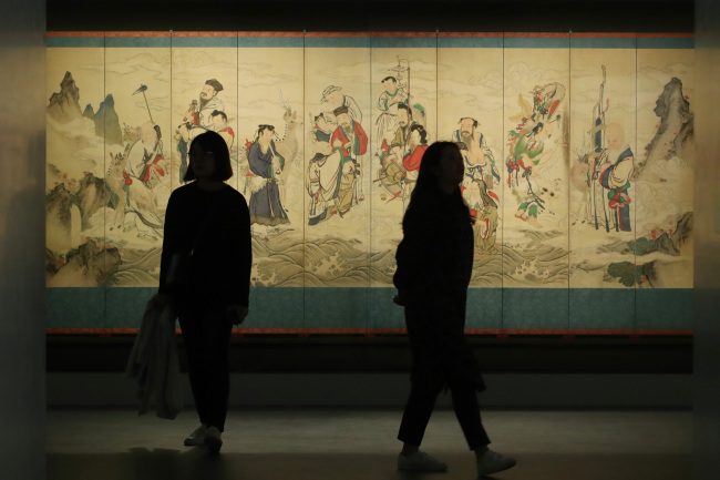 Visitors at Amorepacific Museum of Art walk by “Taoist Immortals Crossing the Sea.” (Yonhap)