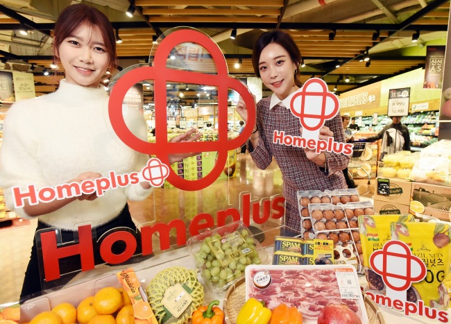 Models hold a new corporate identity of Homeplus at Homeplus store on Thursday. (Homeplus)