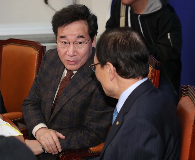 Prime Minister Lee Nak-yon (left) speaks to Rep. Lee Hae-chan, chairman of the ruling Democratic Party of Korea, in a government-ruling party meeting Sunday. (Yonhap)
