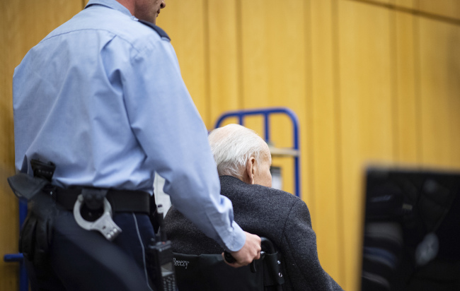 Johann Rehbogen sits in a wheelchair when arriving for the beginning of the third day of his trial at the regional court in Muenster, Germany, Tuesday. (AP-Yonhap)