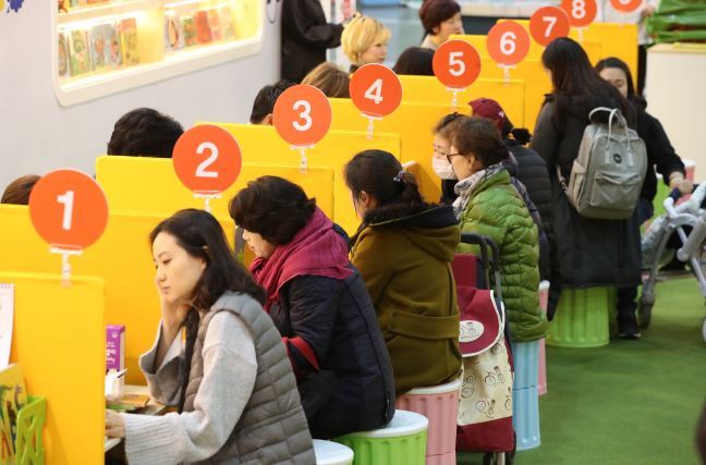 Pre-moms and mothers consult educational programs for thier kids at a fair in Seoul in November. (Yonhap)