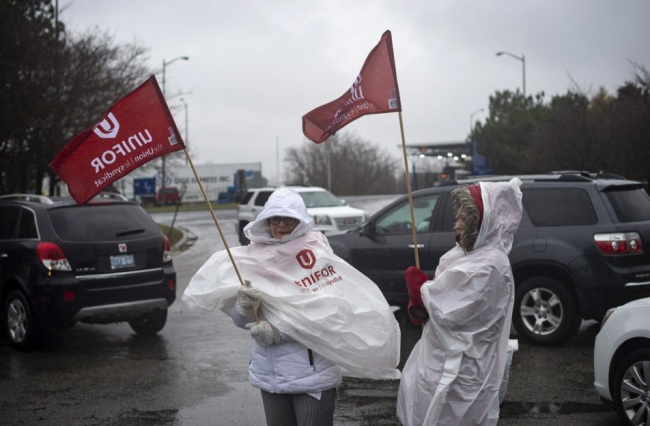 Members of Unifor, the union representing the workers of Oshawa`s General Motors assembly plant, stand near the entrance to the plant in Oshawa, Ontario, Monday, Nov. 26, 2018. General Motors will lay off thousands of factory and white-collar workers in North America and put five plants up for possible closure as it restructures to cut costs and focus more on autonomous and electric vehicles. General Motors is closing the Oshawa plant. (AP)