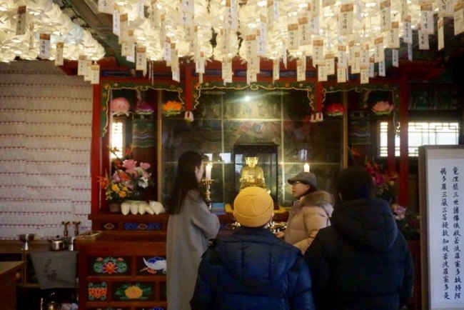 Cultural heritage commentator Jeon Mi-rae explains about a Buddha statue at Heungguksa to templestay participants. (By Im Eun-byel / The Korea Herald)