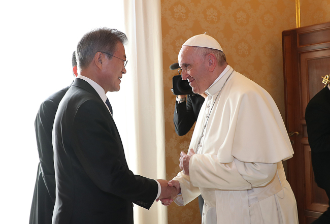 President Moon Jae-in and Pope Francis shake hands at the Vatican during their meeting in October. Cheong Wa Dae