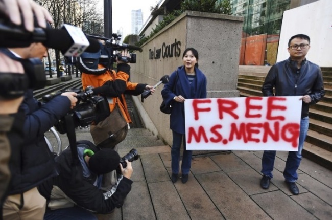 People hold a sign at a Vancouver, British Columbia courthouse prior to the bail hearing for Meng Wanzhou, Huawei`s chief financial officer on Monday, December 10, 2018. Meng Wanzhou was detained at the request of the US during a layover at the Vancouver airport on Dec. 1. (The Canadian Press-AP)