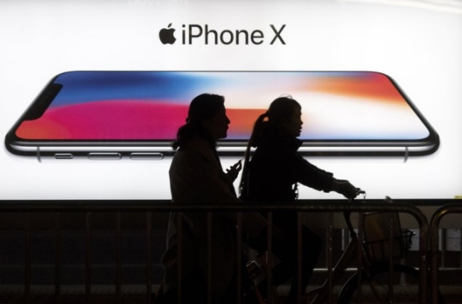 In this Nov. 6, 2017, file photo, residents pass by an advertisement for the iPhone X in Beijing, China. U.S. chipmaker Qualcomm says it’s won an order in a Chinese court banning some Apple phones in China as part of a long-running dispute over patents. Qualcomm said Monday, Dec. 10, 2018, that the Fuzhou Intermediate People’s Court in China has granted preliminary injunctions ordering four Chinese subsidiaries of Apple to stop selling and importing iPhones 6S through X. (AP)