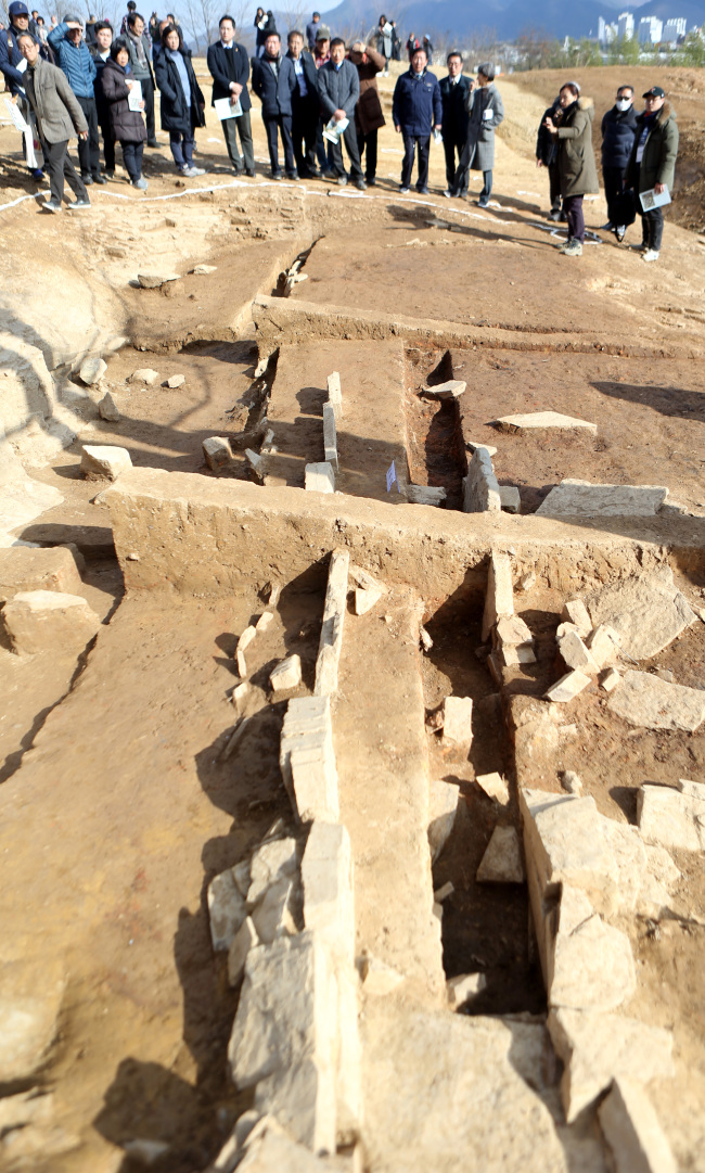 A Cultural Heritage Administration official briefs reporters on what is believed to be the site of a Gaya royal palace site. (Cultural Heritage Administration)