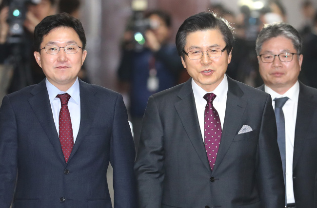 Former prime minister Hwang Hyo-ahn (center) walks to a press conference after announcing his Liberty Korea Party membership on Tuesday. (Yonhap)