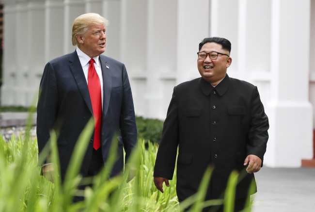 In this June 12, 2018, file photo, US President Donald Trump (left) and North Korea leader Kim Jong Un walk from their lunch at the Capella resort on Sentosa Island in Singapore. (AP-Yonhap)