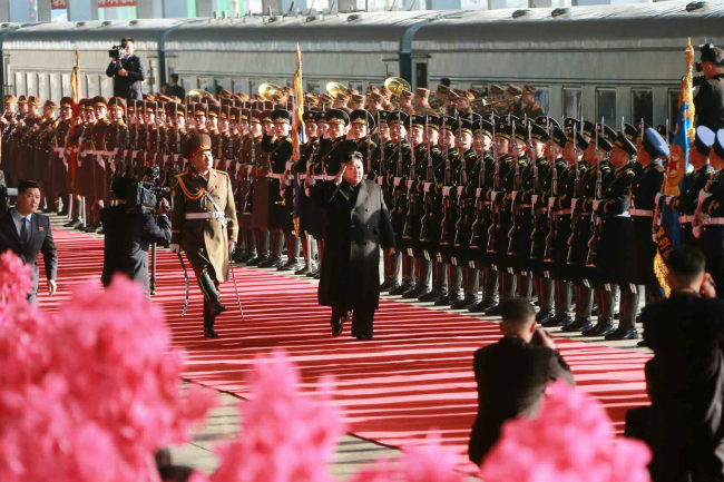 North Korean leader Kim inspects guards before boarding an armored train. (Yonhap)