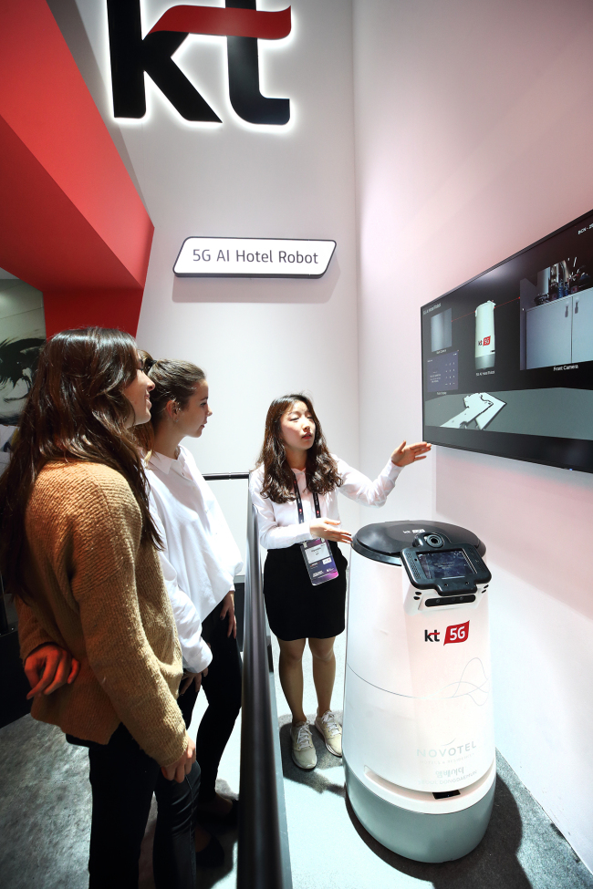 Visitors listen to how 5G is applied for KT’s hotel services at Mobile World Congress 2019 on Tuesday. (KT)